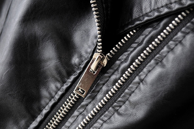Close-up of a stylish zipper on a women's vintage PU leather motorcycle jacket, showcasing its rock-inspired design.