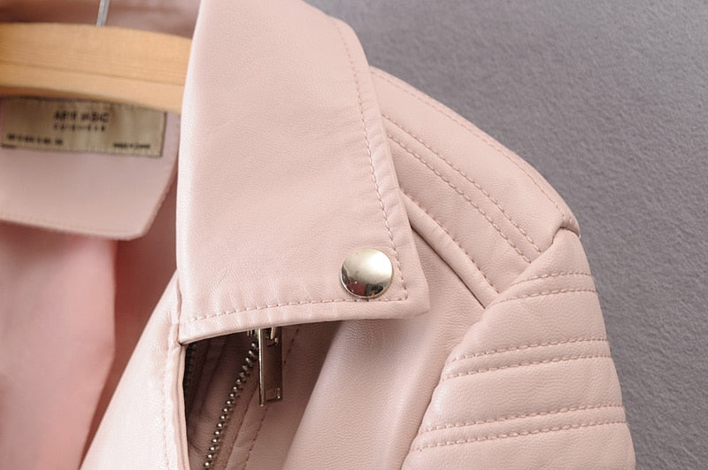 Close-up of vintage pink faux leather motorcycle jacket with stylish collar and zipper details.