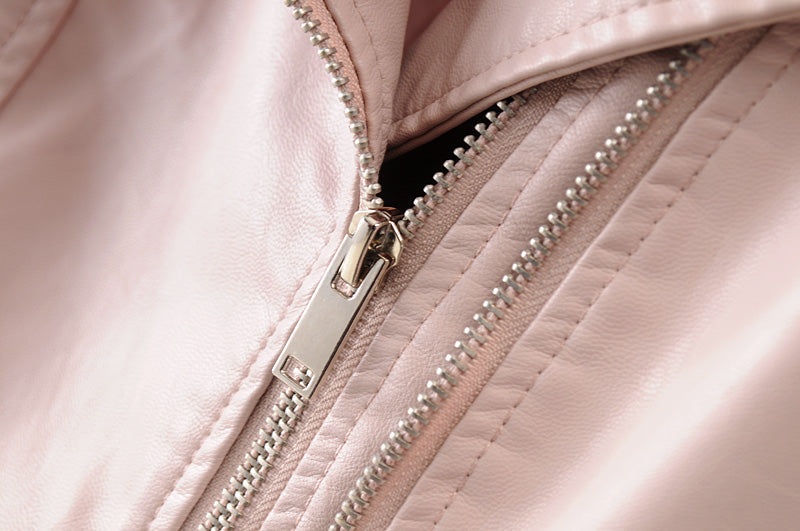 Close-up of zippers on a women's vintage faux leather motorcycle jacket, showcasing stylish detail and quality craftsmanship.