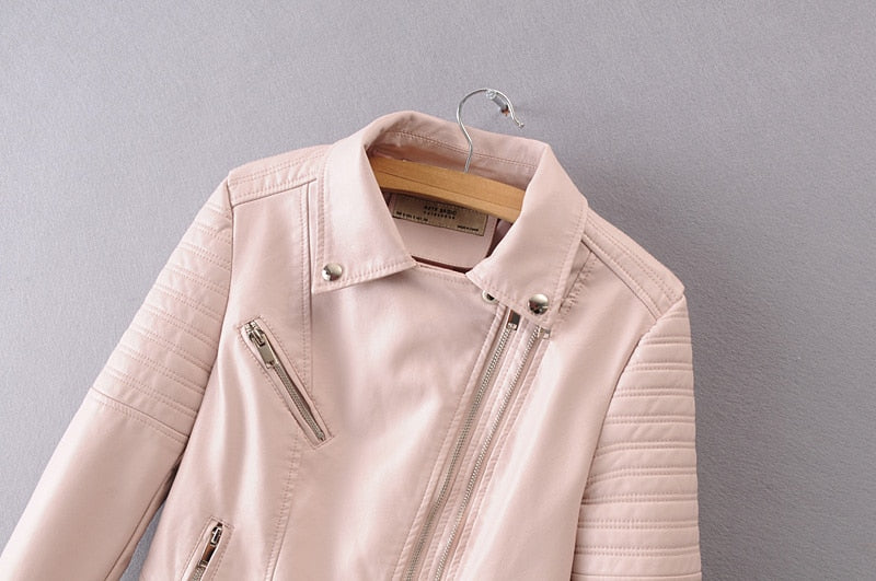 Close-up of vintage pink faux leather motorcycle jacket with stylish zippers and quilted sleeves, perfect for a rock-inspired look.