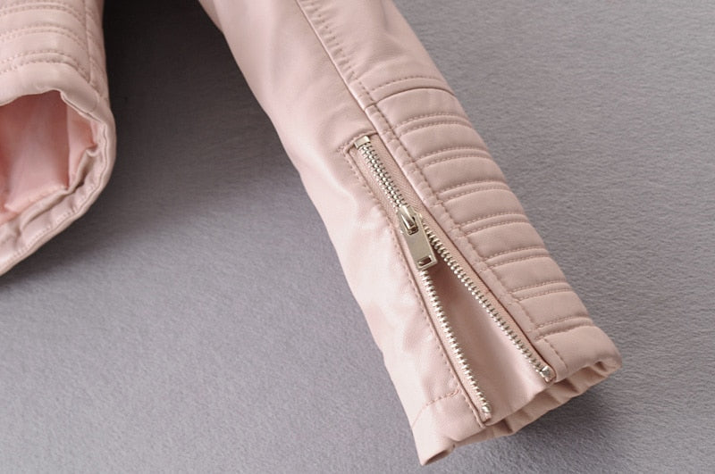 Close-up of the stylish zipper detail on a women's vintage pink faux leather motorcycle jacket sleeve.