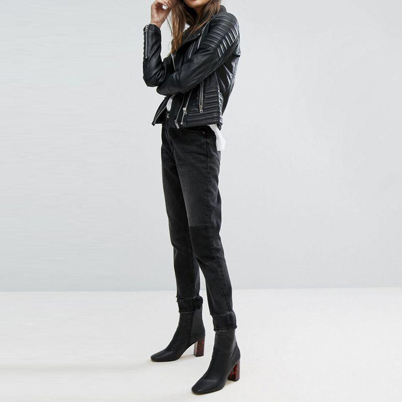 Woman in stylish vintage PU leather motorcycle jacket paired with black jeans and ankle boots, showcasing edgy biker fashion.