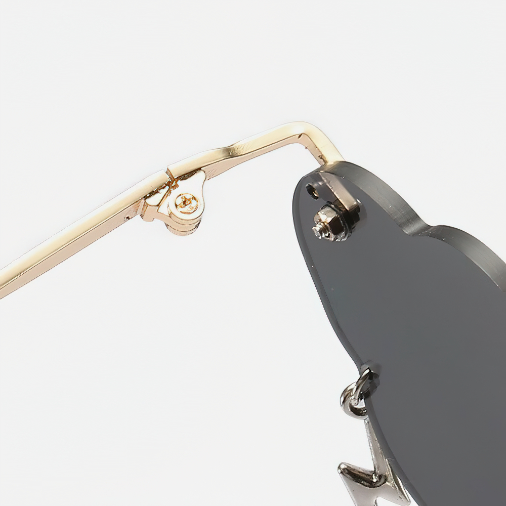 Close-up of vintage rimless cloud sunglasses showcasing stylish gold frame and unique shape.
