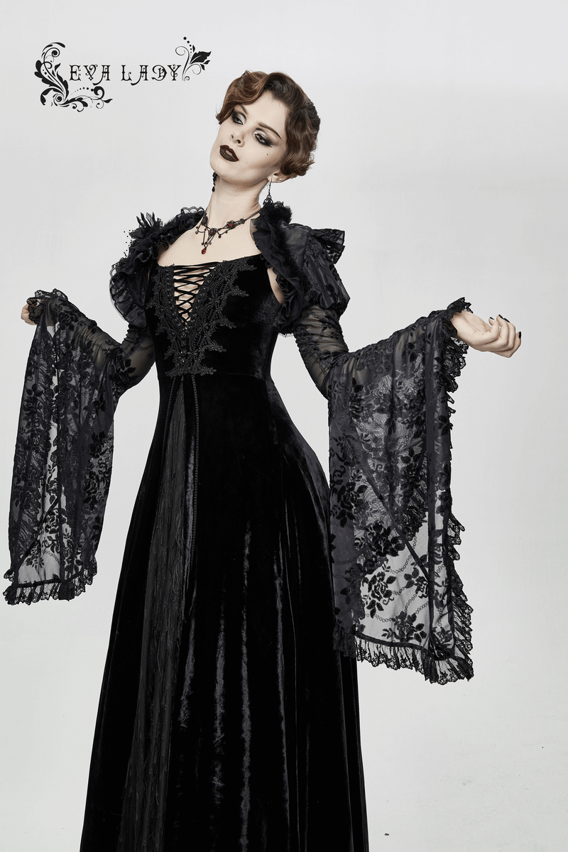 Elegant model wearing a vintage off-shoulder black velvet long dress with lace details and dramatic bell sleeves.