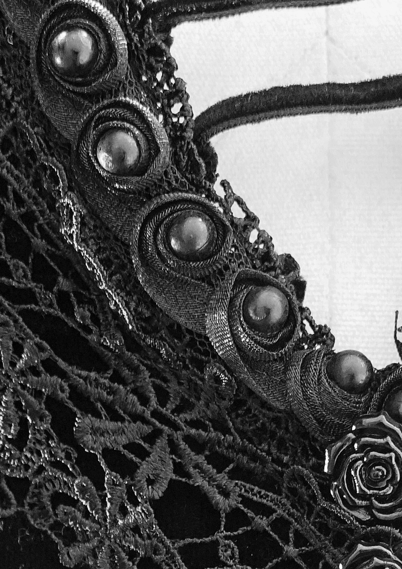 Close-up of gothic black dress lace bodice and decorative buttons, showcasing elegant velvet detailing.