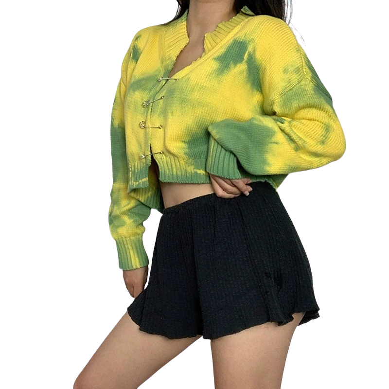 Trendy women's vintage cropped cardigan in yellow and green tie-dye, paired with black shorts for a casual look.