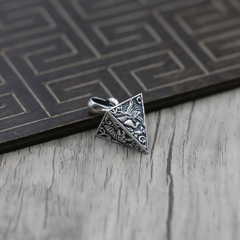Vintage pyramid-shaped silver pendant adorned with animal motifs, perfect for unique jewelry lovers.