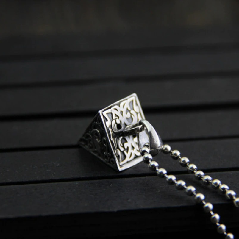 Vintage pyramid-shaped silver pendant with intricate animal designs on a chain, perfect for aesthetic jewelry lovers.