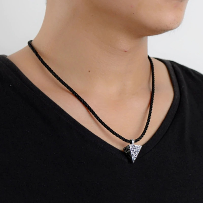 Man wearing a vintage silver pyramid pendant necklace on a black rope chain for stylish accessory vibes.