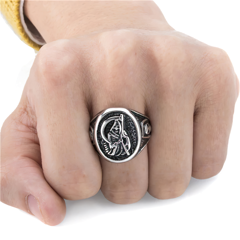 Close-up of a hand wearing a vintage stainless steel reaper skull ring, showcasing its gothic design and intricate details.