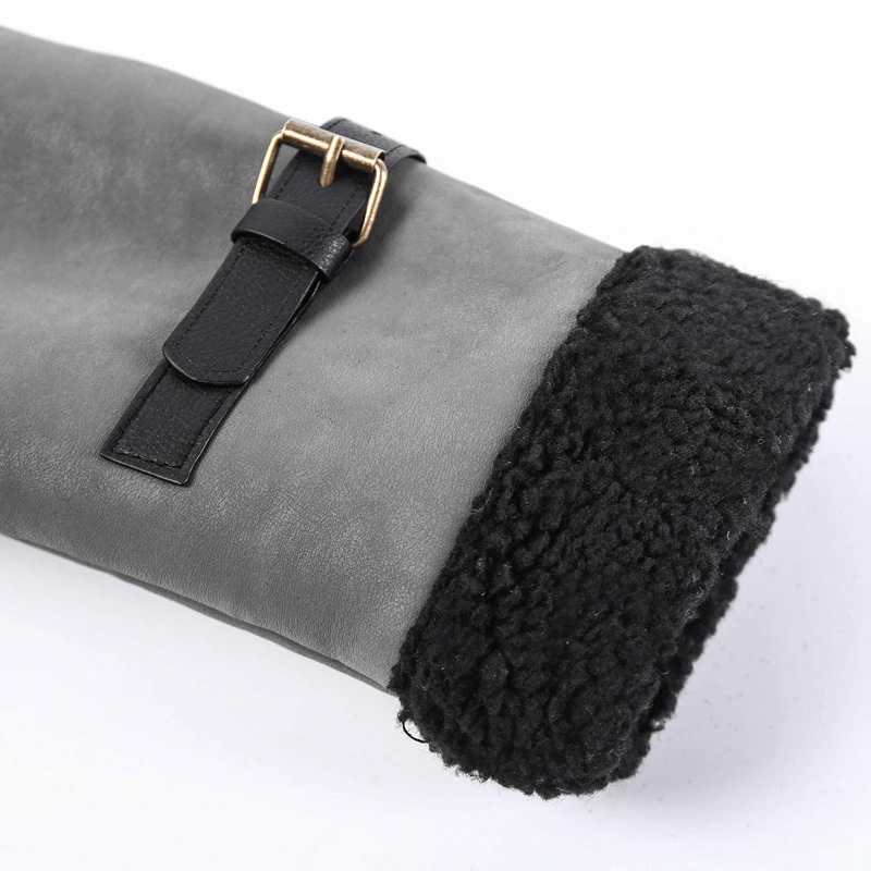 Close-up of a vintage leather jacket sleeve with a buckle and fuzzy black lining.