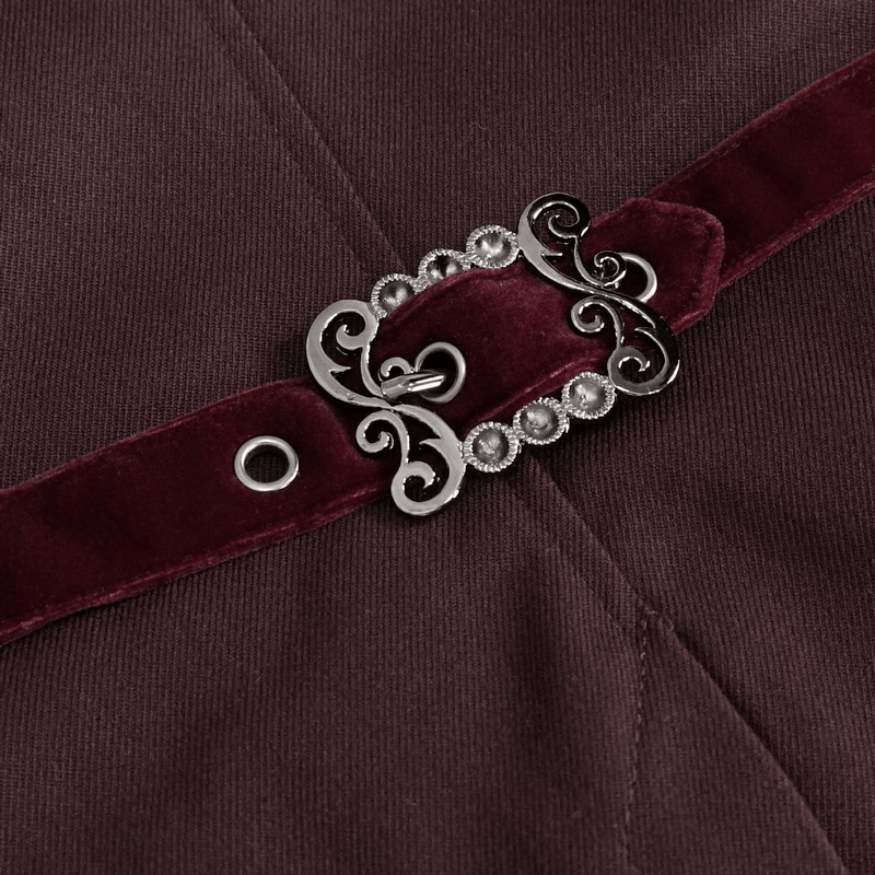 Close-up of a vintage-style buckle on a men's red tailcoat, showcasing intricate design and luxurious velvet fabric.
