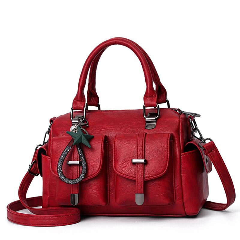 Vintage red women's handbag in soft leather with star pendant and multiple pockets, perfect for stylish outings.