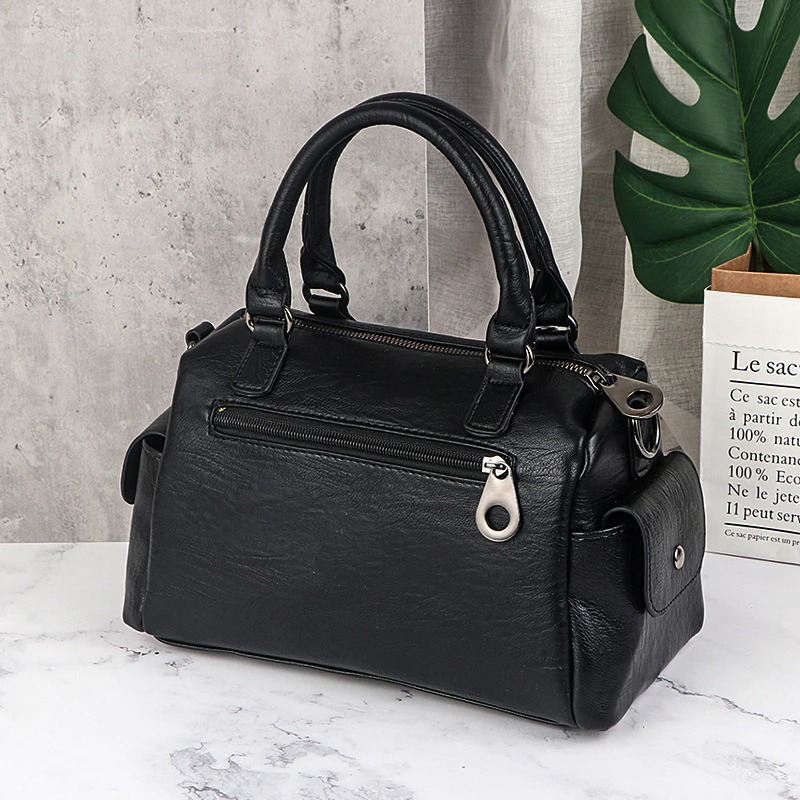 Vintage women's black leather handbag with star pendant and top handles, stylish and functional multi-pocket design.
