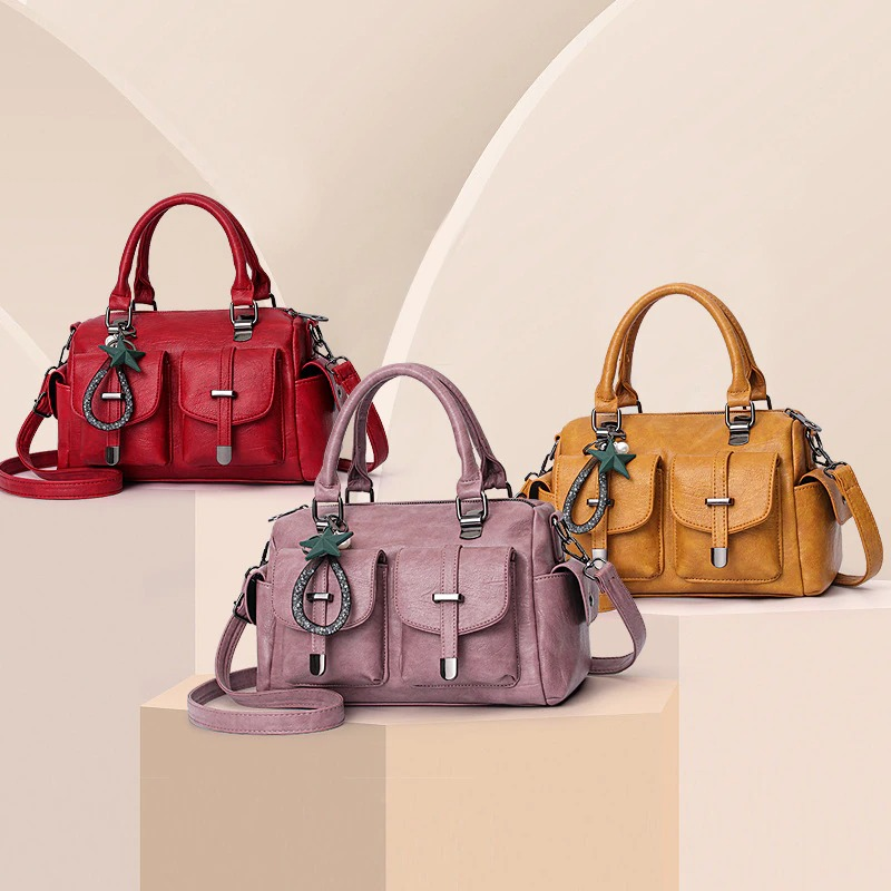 Vintage women handbags with star pendants in red, pink, and yellow soft leather on display.