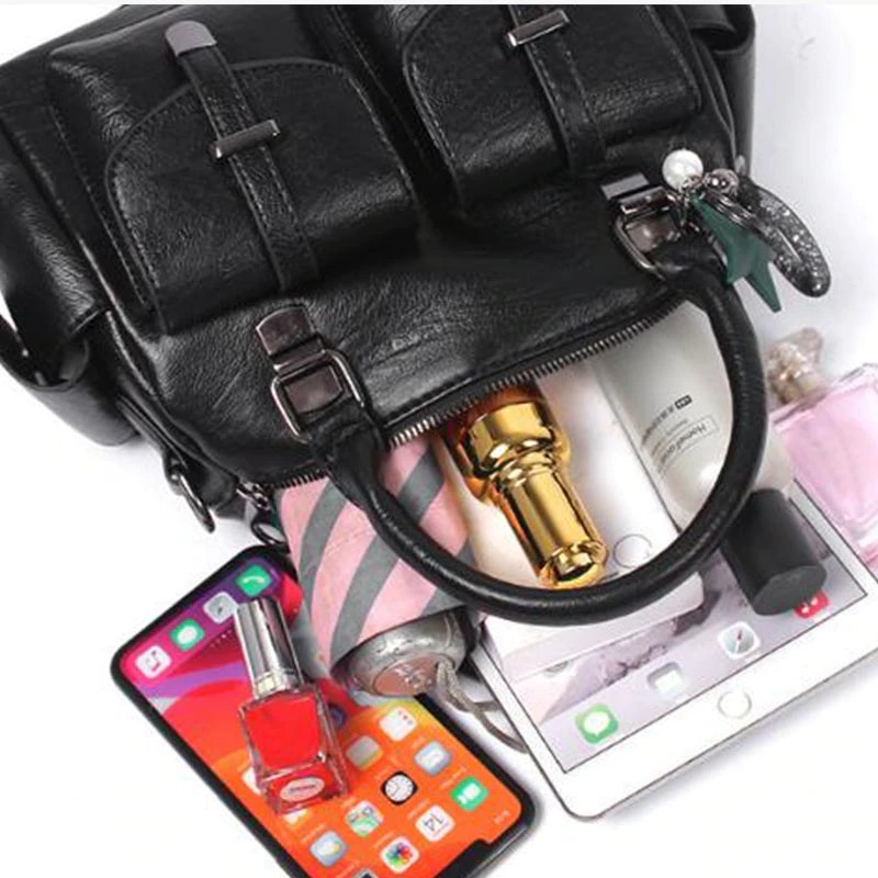 Black vintage women handbag with star pendant, showcasing multiple pockets and contents like phone and cosmetics.