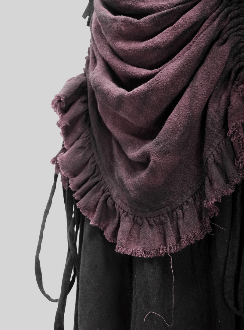 Close-up of a vintage multi-layered ruched skirt with a dark purple ruffled hem, showcasing punk style elegance.