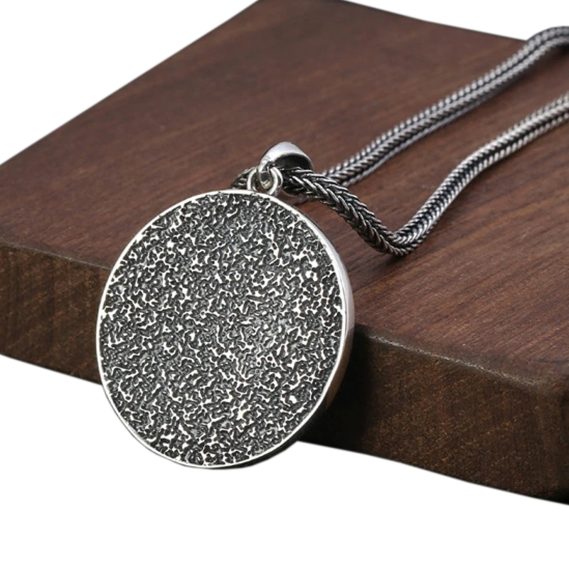 Vintage rock style silver pendant on a wooden surface, perfect for unisex outfits and scorpio enthusiasts.
