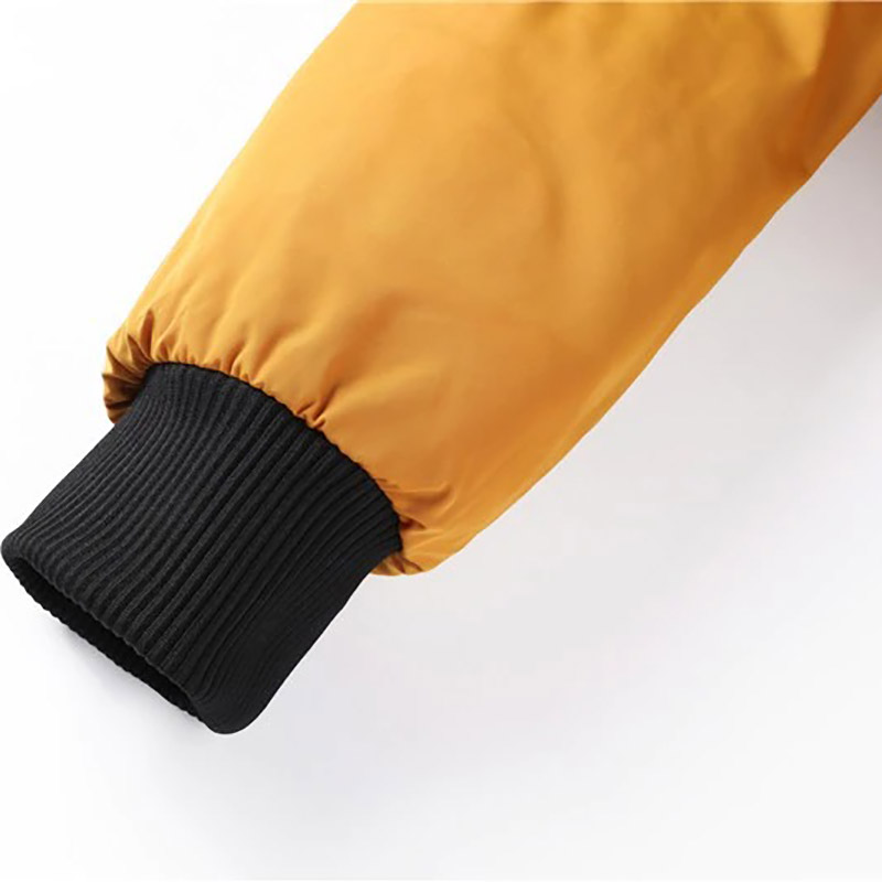Close-up of the cuff of a water-resistant men's bomber jacket in yellow with black ribbed detail.