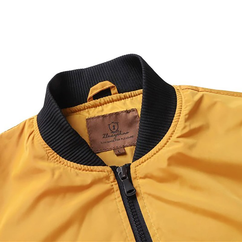 Close-up of yellow water-resistant men's bomber jacket collar and zipper, perfect for casual outdoor wear.