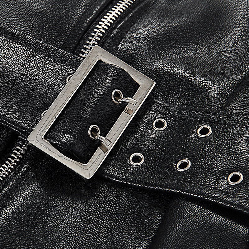 Close-up of a silver buckle on a black leather belt with grommets, perfect for Gothic fashion.