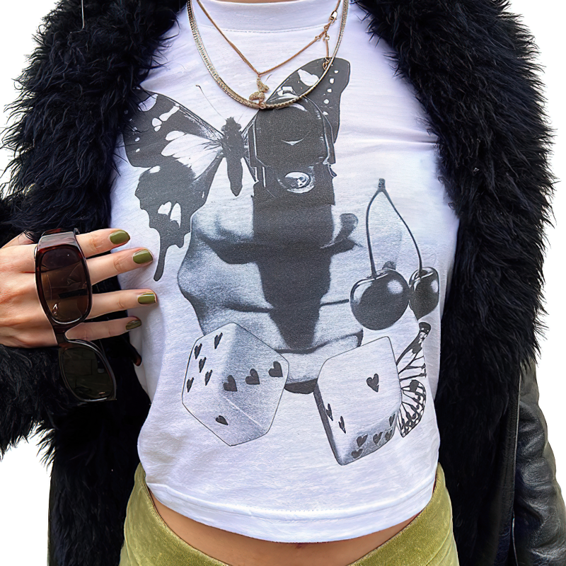 Stylish female model wearing a white crop top with butterfly and cherry print, showcasing alternative fashion.