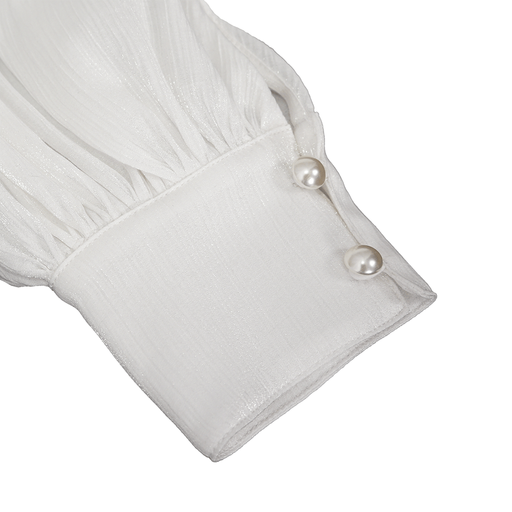 Elegant white blouse sleeve detail with pearl buttons and soft pleats, perfect for a chic gothic style.