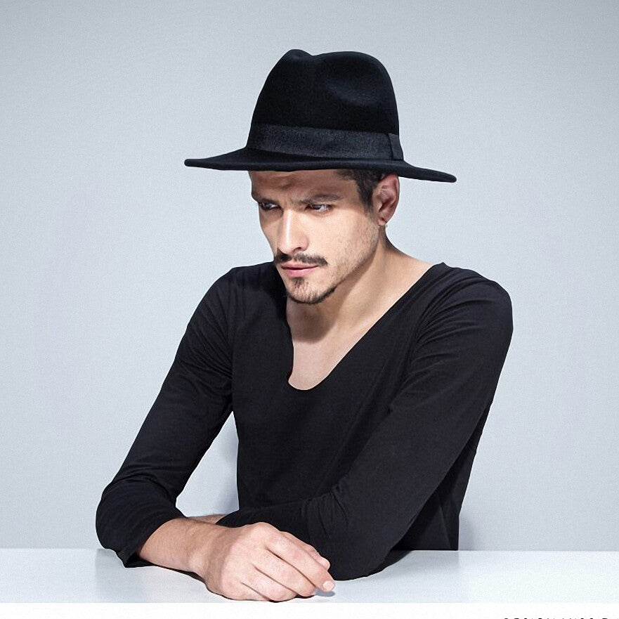 Stylish man wearing a wide brim black wool fedora, perfect for rock style fashion or cosplay outfits.