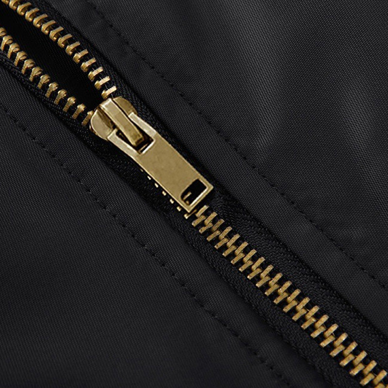 Close-up of the gold zipper detail on a black cotton padded pilot bomber jacket.