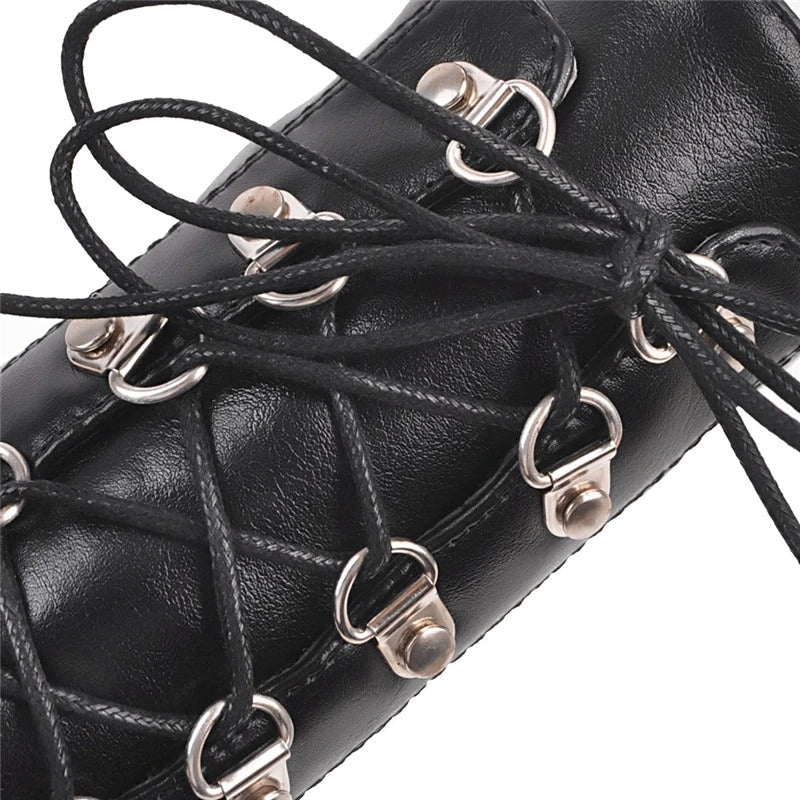 Close-up of black women's gothic fashion boots showing detailed lacing and silver eyelets.