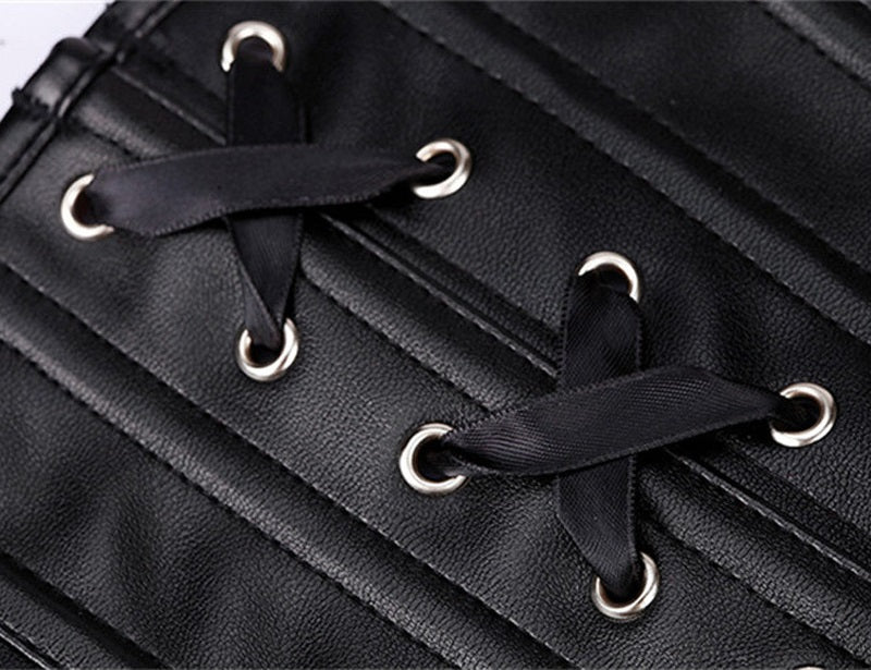Close-up of black faux leather bustier corset with decorative lacing details and silver eyelets.