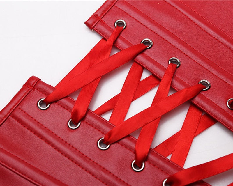 Close-up of red faux leather corset lacing with satin ribbons and metal grommets, showcasing its intricate design.