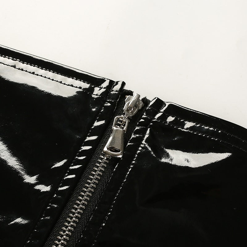 Close-up of shiny black zipper on women's bralette crop top, showcasing stylish design and quality craftsmanship.