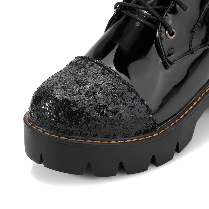 Close-up of women's black ankle boot with glittery toe and thick heel, showcasing stylish casual fashion.