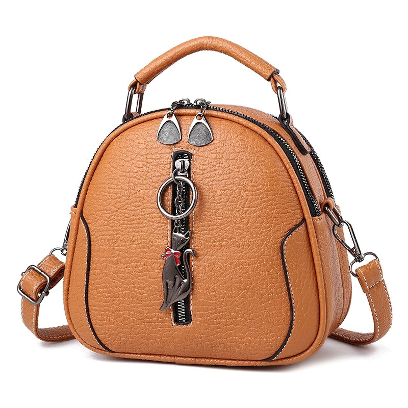 Stylish women's crossbody small shell bag in tan PU leather with cat pendant, perfect vintage accessory.