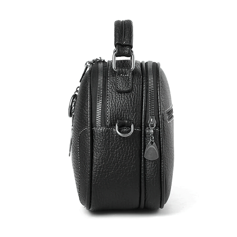 Side view of a chic women's crossbody small shell bag in black PU leather with zippers and a stylish pendant.