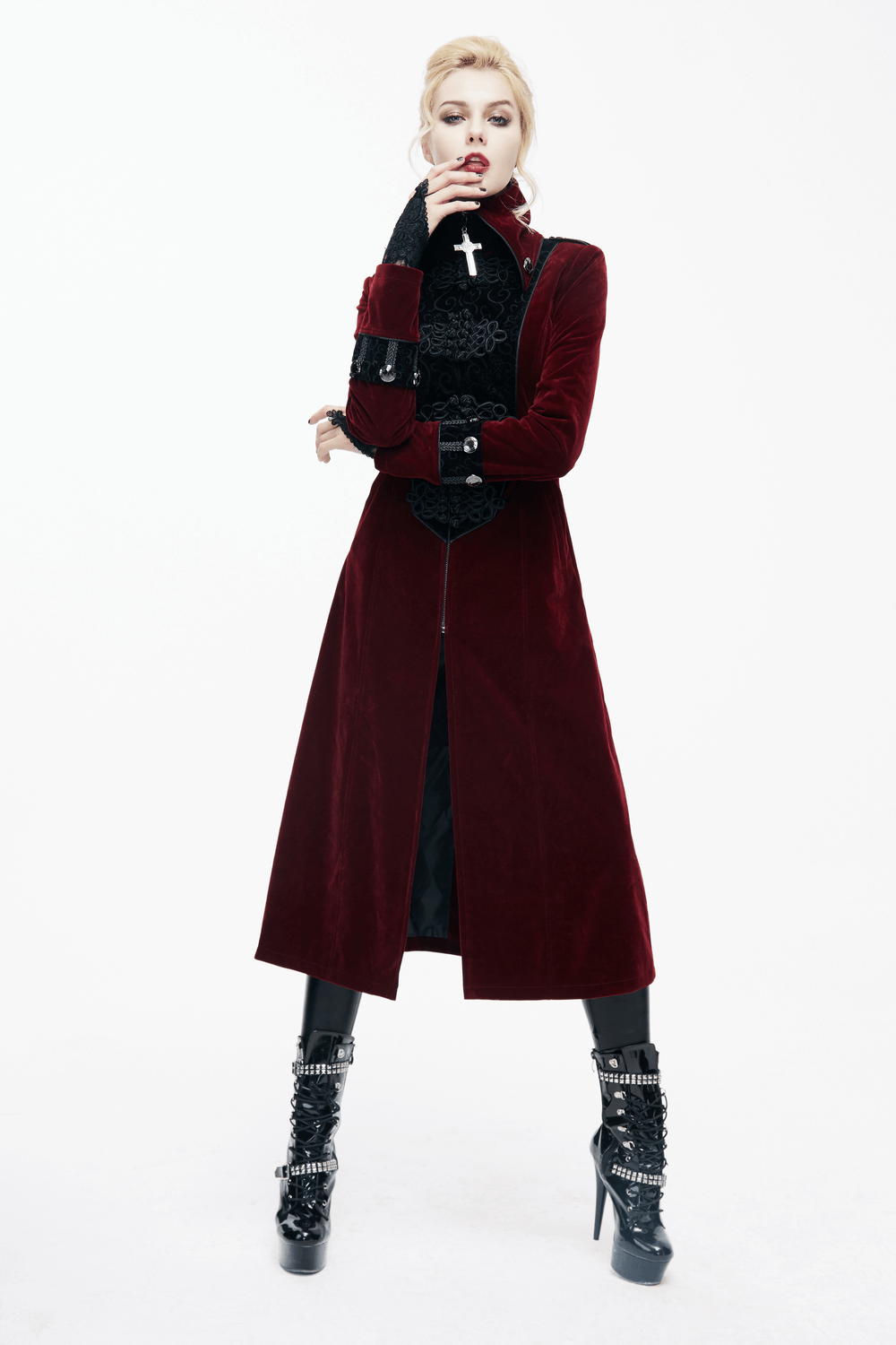 Women in a gothic style long red coat with lace inserts and high collar, showcasing alternative fashion.