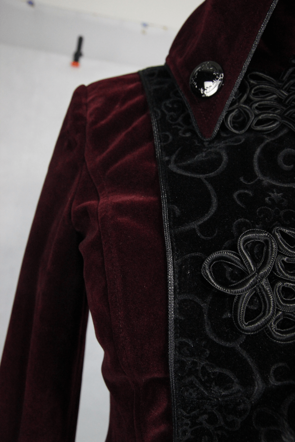 Close-up of women's gothic style red coat featuring lace details and high collar, perfect for alternative fashion.