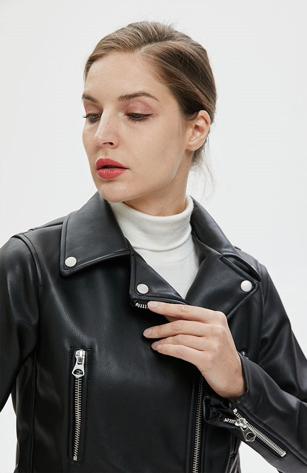Stylish woman in a faux leather biker jacket with zippers and a standing collar, exuding rock chic vibes.