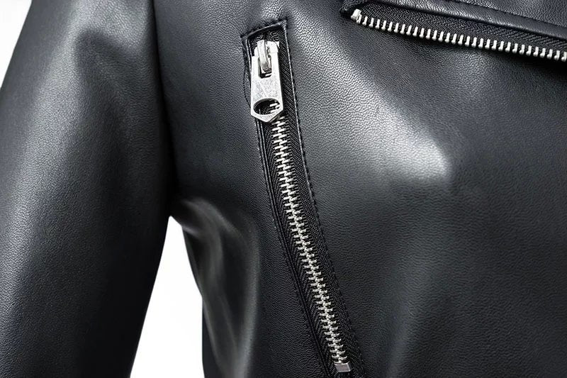 Close-up of a faux leather women's biker jacket showing shiny zipper details and sleek black fabric.