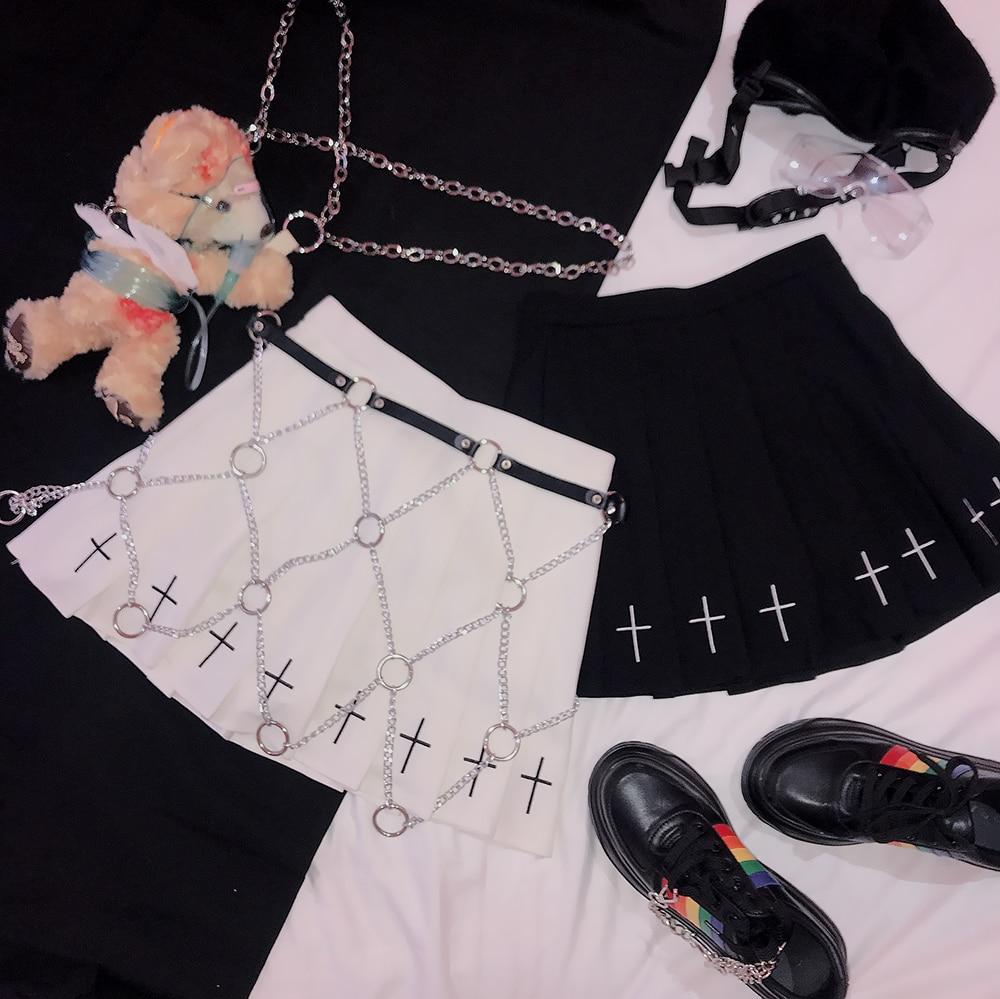 Two rock star skirts, one black and one white with chain details and crosses, styled with accessories and shoes.