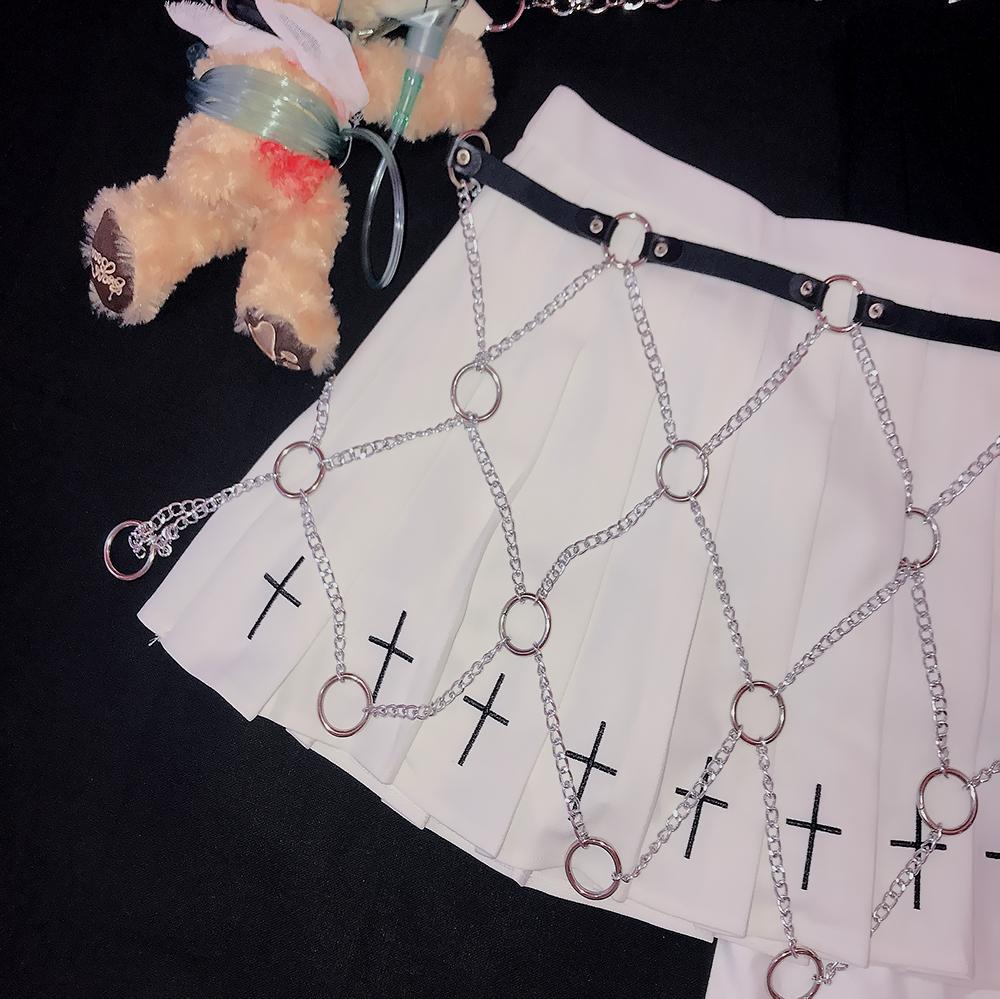 Faux leather link chains body harness on a white skirt with cross decorations, perfect for rock star fashion.
