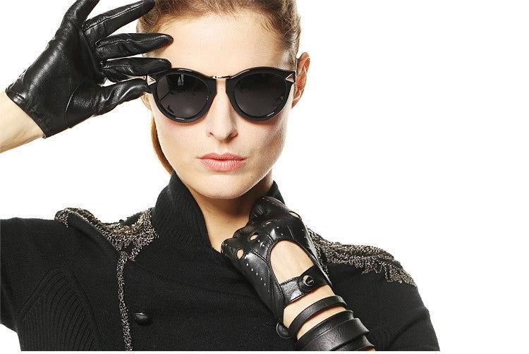 Stylish woman wearing cat-eye sunglasses and genuine leather gloves, showcasing alternative fashion and rock style.