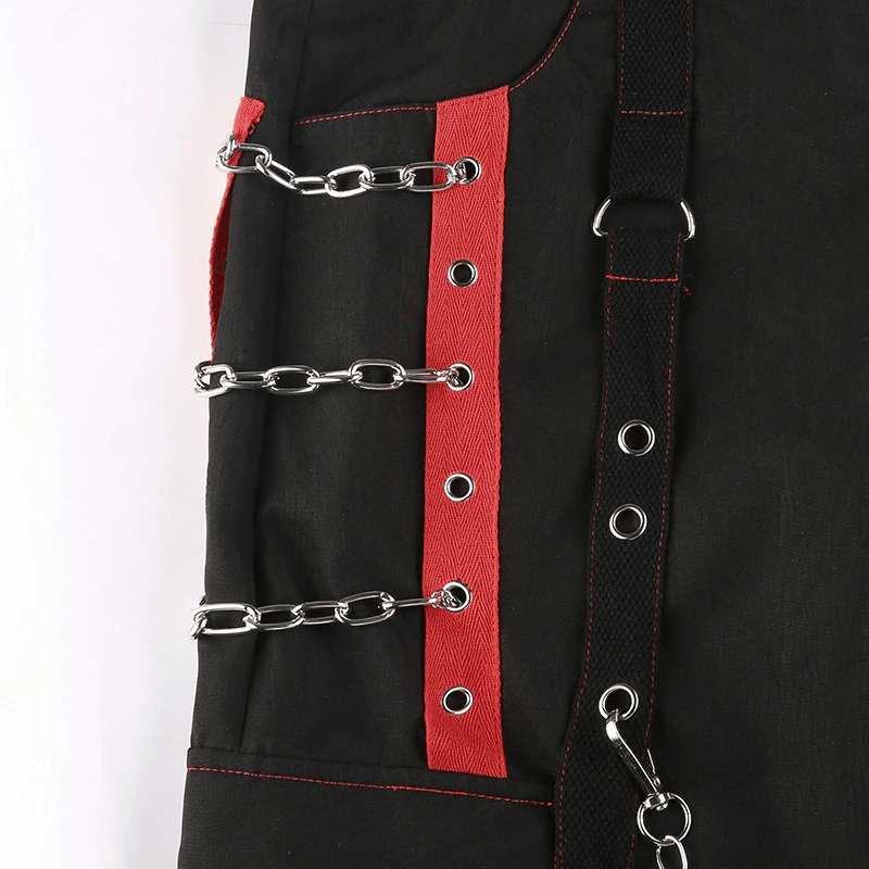 Close-up of women's black punk cargo pants featuring chain inserts and red accents for a stylish look.