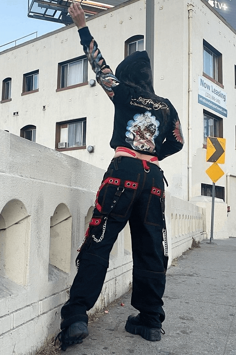 Woman wearing gothic punk cargo pants and stylish hoodie, showcasing a trendy street fashion look.