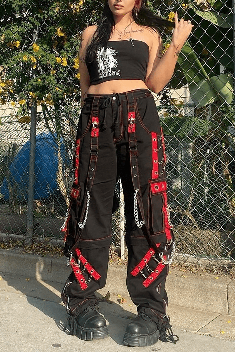Women in black gothic punk cargo pants with chain details, paired with a crop top, showcasing edgy street style.