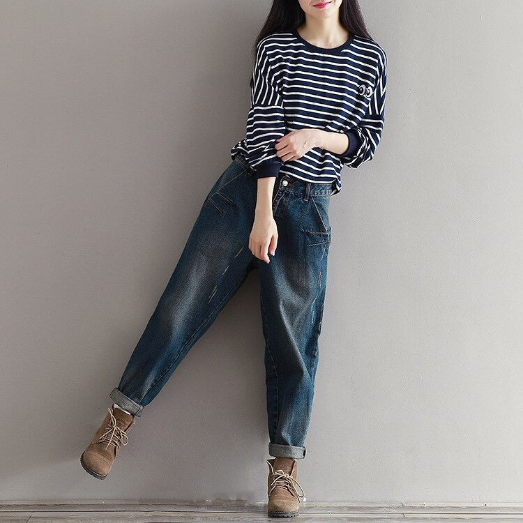 Stylish woman in striped shirt and plus size boyfriend jeans, showcasing urban alternative fashion.