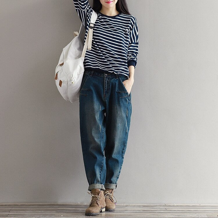 Stylish woman in striped top and relaxed fit plus size jeans, showcasing alternative urban fashion.