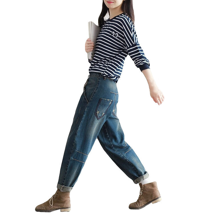 Stylish woman in urban boyfriend jeans walking confidently, perfect for alternative fashion lovers.