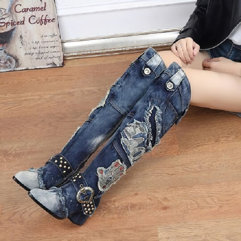 Women’s knee-high boots in denim with rivet detailing and embroidery, perfect for alternative style fashion.